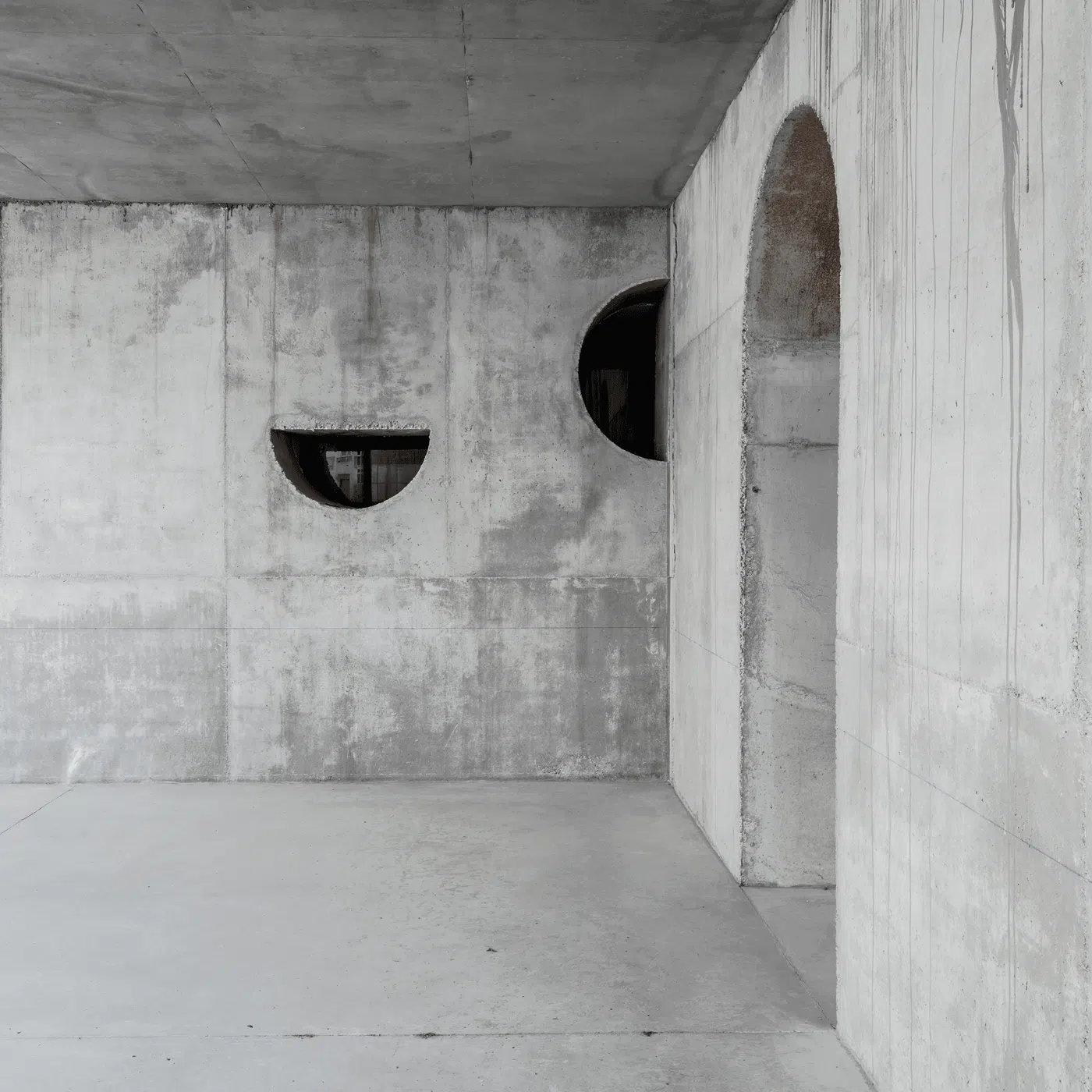 Interior de hormigón con ventanas circulares, una obra de DJ Arquitectura
