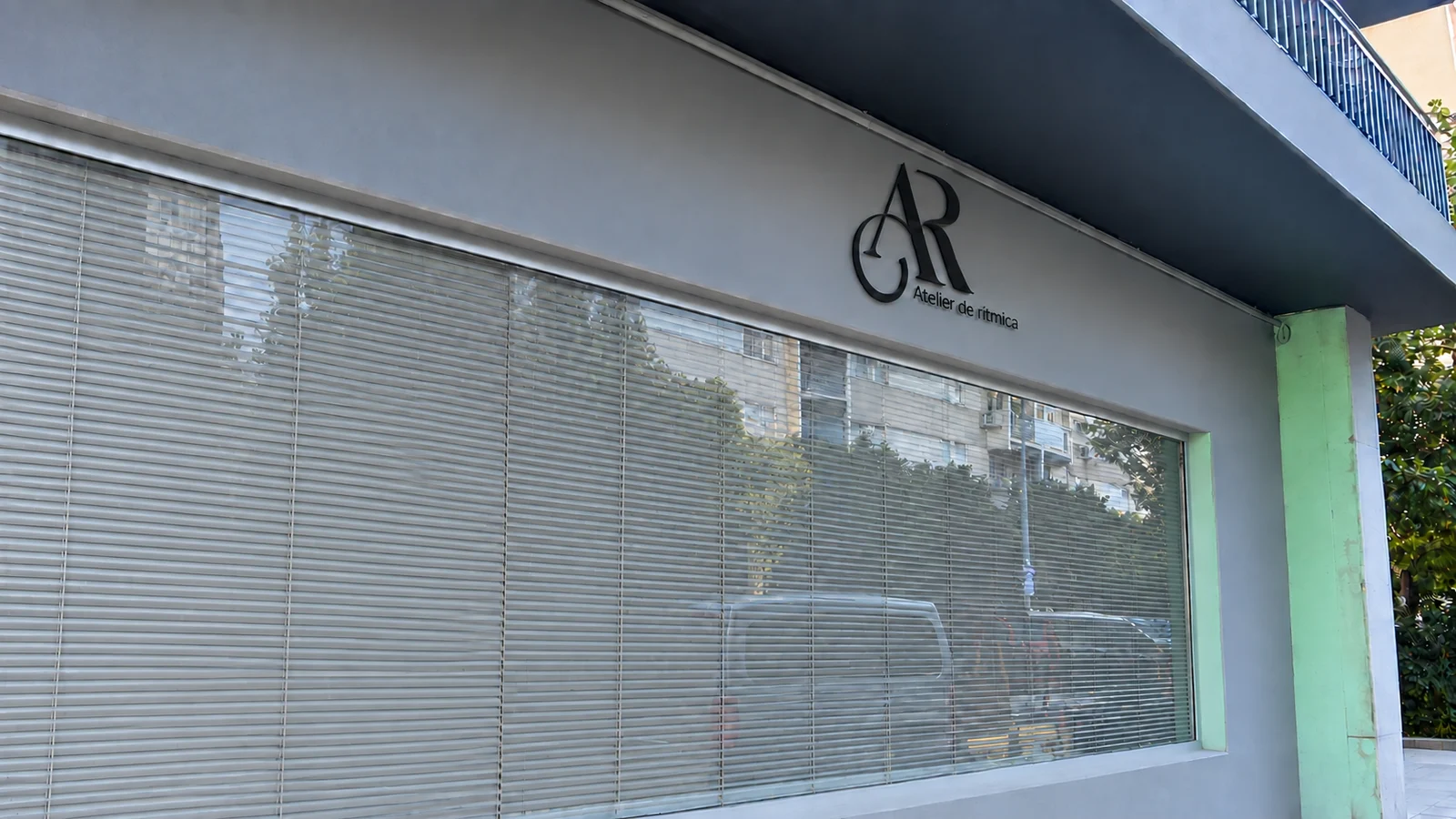 Fachada de la tienda de Atelier de Rítmica con el rótulo AR sobre la banda gris