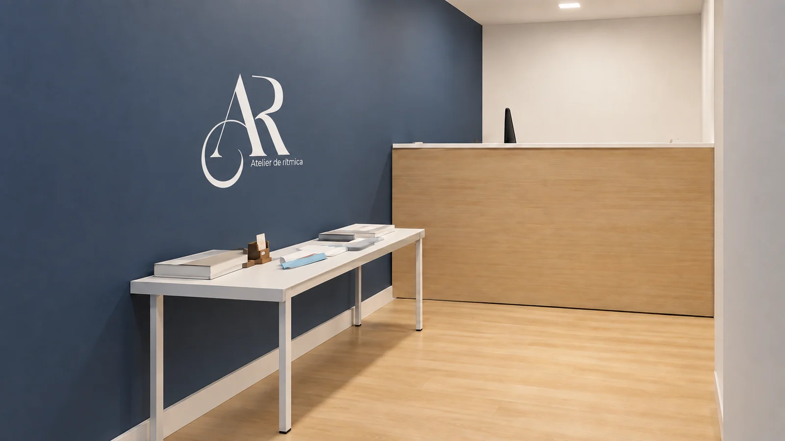 Recepción con el monograma AR en blanco sobre la pared azul marino y el mostrador de madera